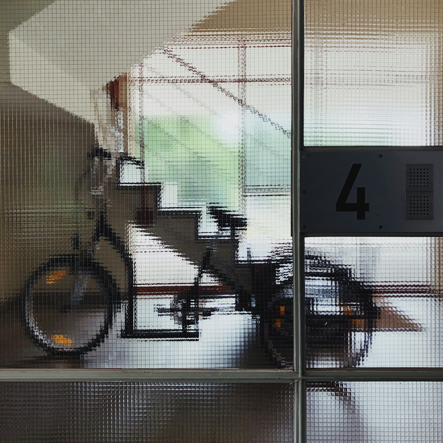 A bicycle parked by a staircase near a number four sign.